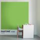Une pièce blanche comprend un grand carré vert vif, étiqueté Pantone 15-0343 Greenery. Devant, un bureau blanc – idéal pour réfléchir à votre prochain projet de création de site web – est posé sur une tasse et un petit objet violet. Une chaise blanche aux pieds en bois est installée à côté du bureau.
